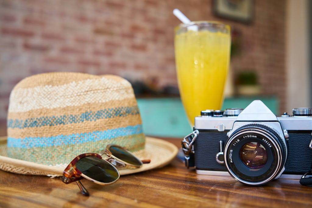 Image Gallery 7 A stylish scene showcasing a vintage camera, hat, and orange juice, evoking summer travel vibes.
